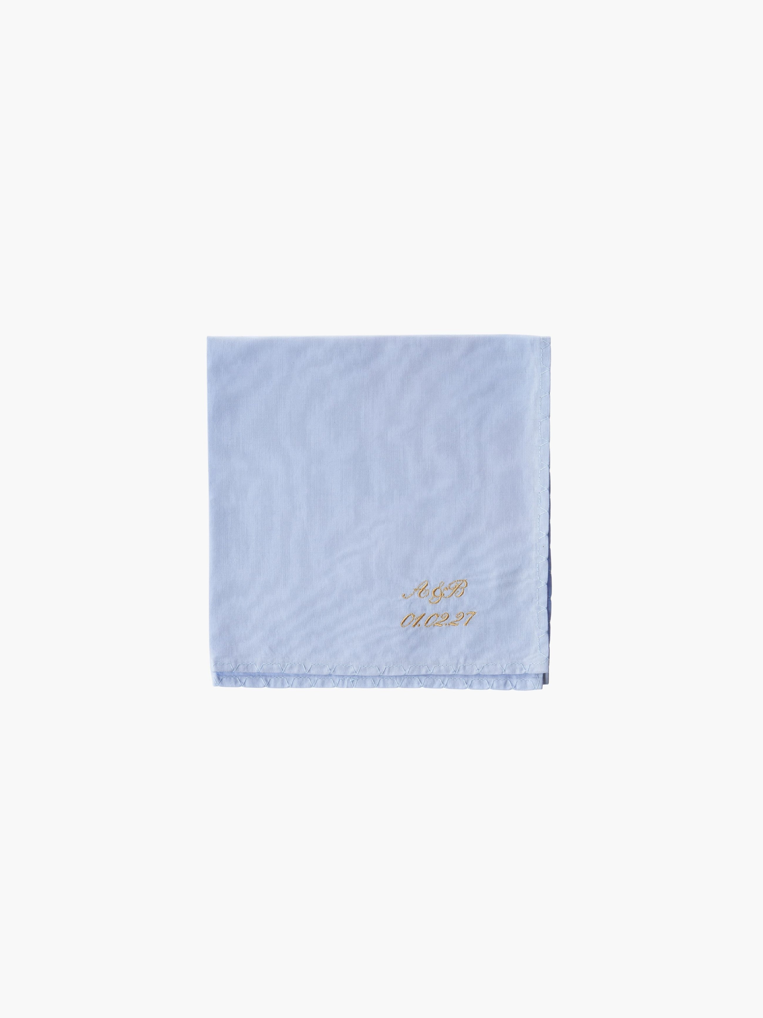 A blue cotton embroidered square handkerchief, embroidered with initials and the date in gold.