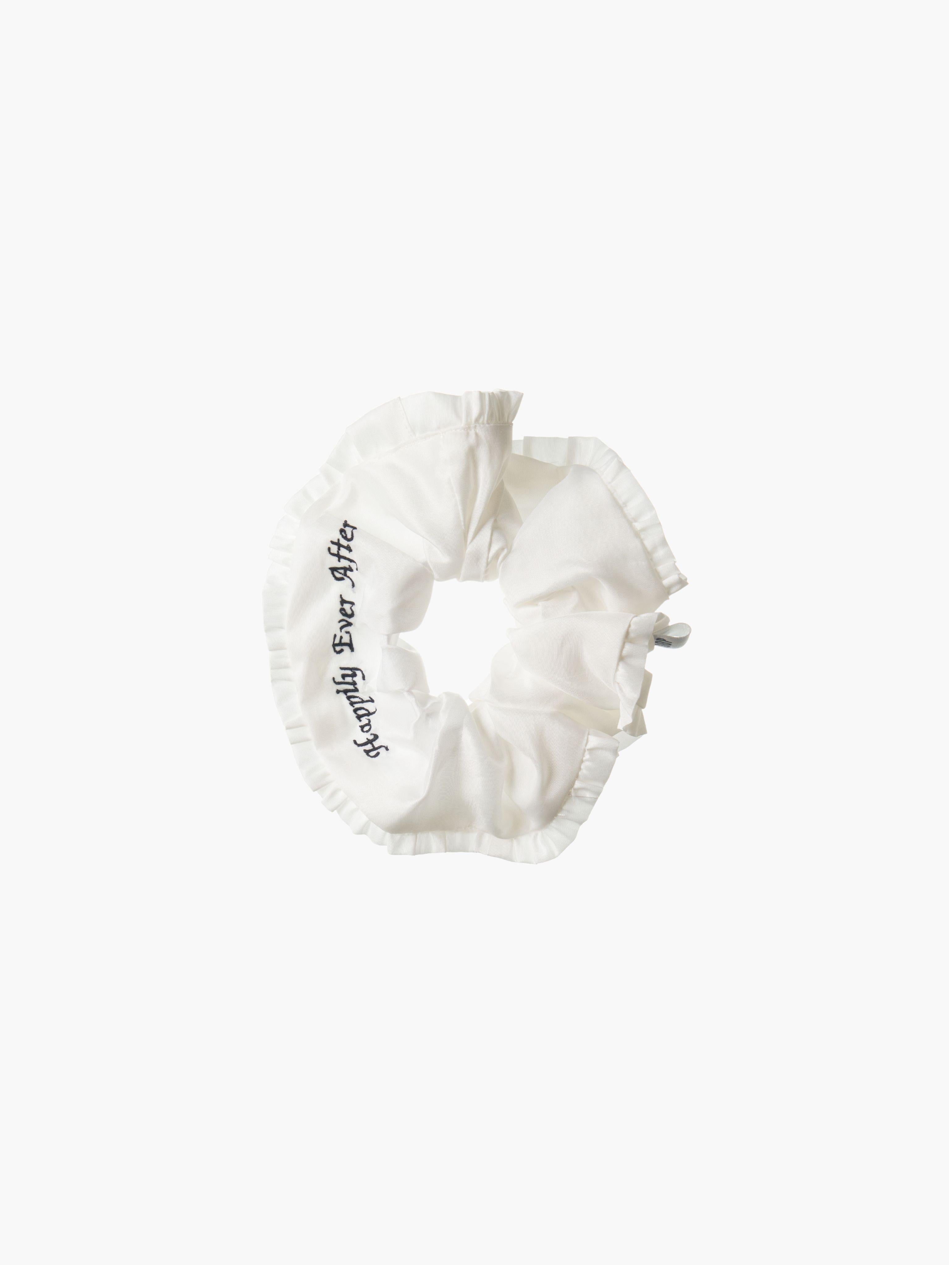 Ivory ruffled scrunchie with black embroidery that reads 'happily ever after' on a white background