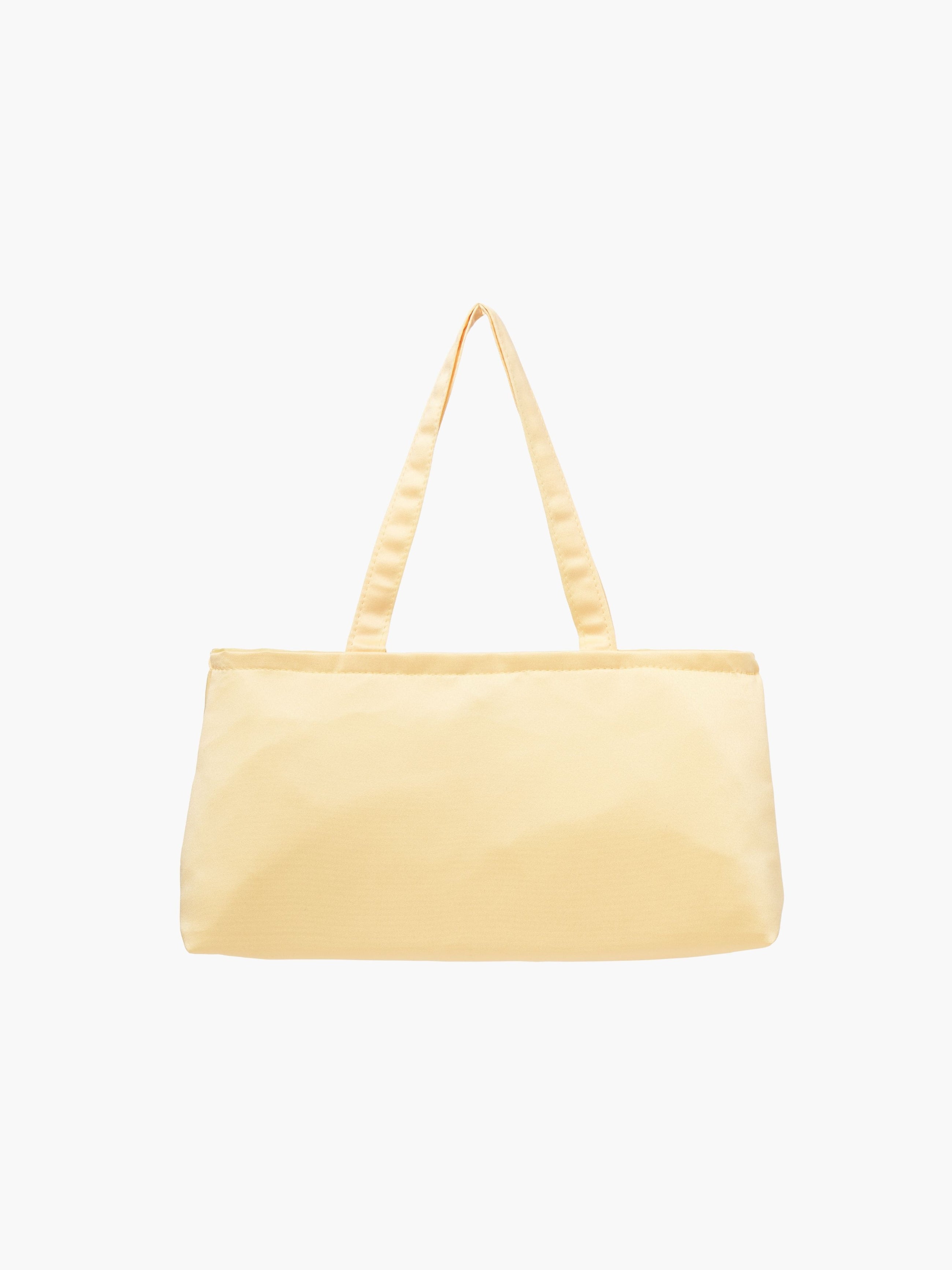A yellow satin baguette handbag with two handles.