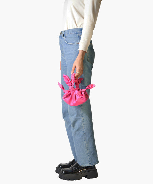 Baby furoshiki handbag in deadstock cerise taffeta model holding jeans