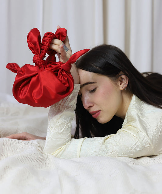Model laying down holding red baby furoshiki bag
