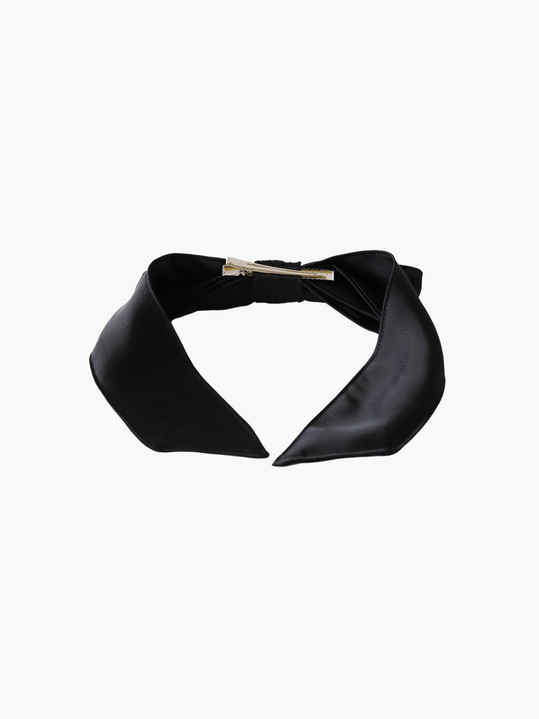 back view of black satin hair bow with a silver crocodile clip on a white background