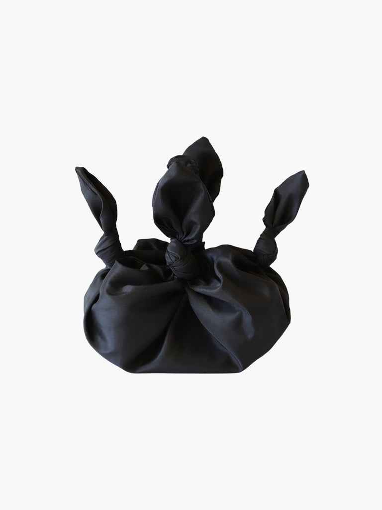 Black knotted fabric bag on a white background