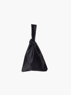 Black satin knot bag against a plain white background. The elegant bag has a twisted handle and sleek, glossy fabric, exuding a chic, minimalist style.