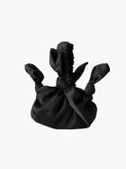 Black satin knotted fabric bag on a white background