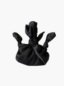 Black satin knotted fabric bag on a white background