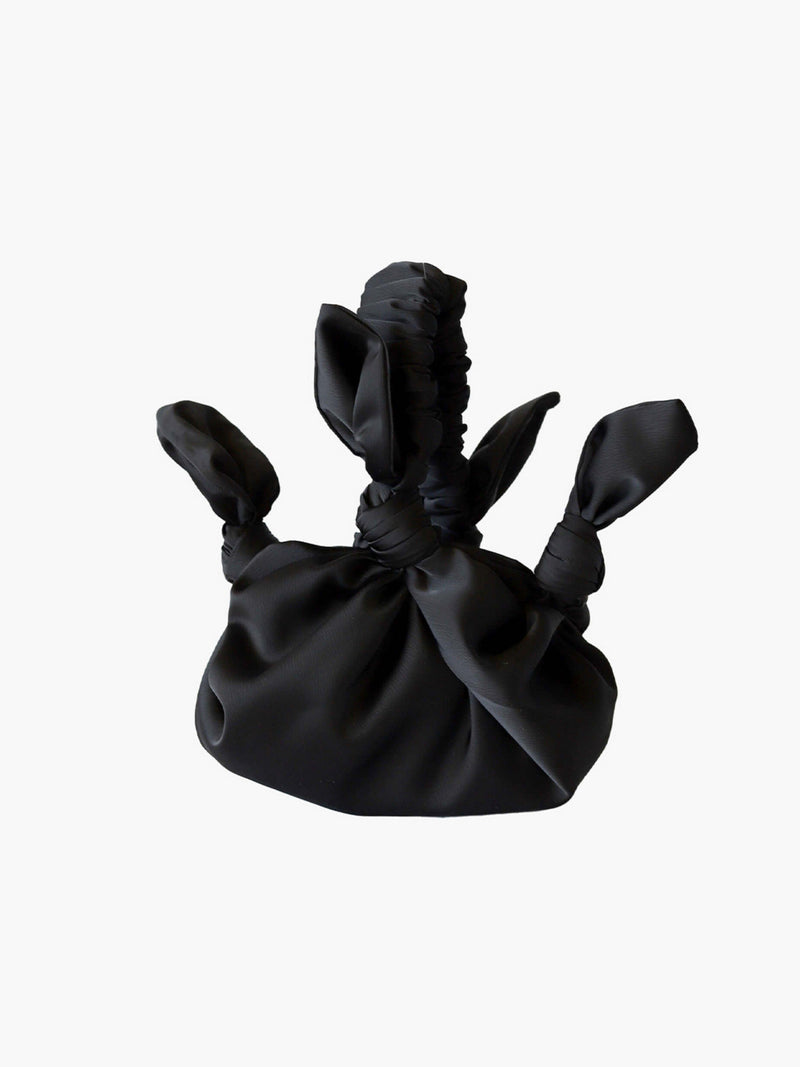 Black satin knotted fabric bag on a white background