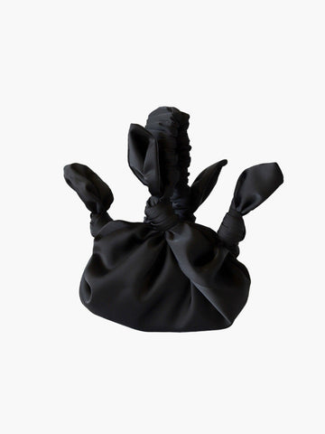 Black satin knotted fabric bag on a white background
