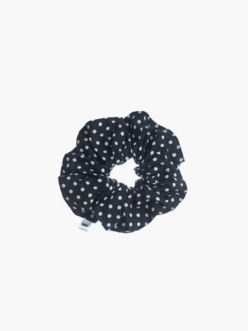 Black scrunchie with white polka dots on a white background