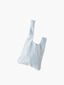 Blue satin knot bag against a plain white background. The elegant bag has a twisted handle and sleek, glossy fabric, exuding a chic, minimalist style.