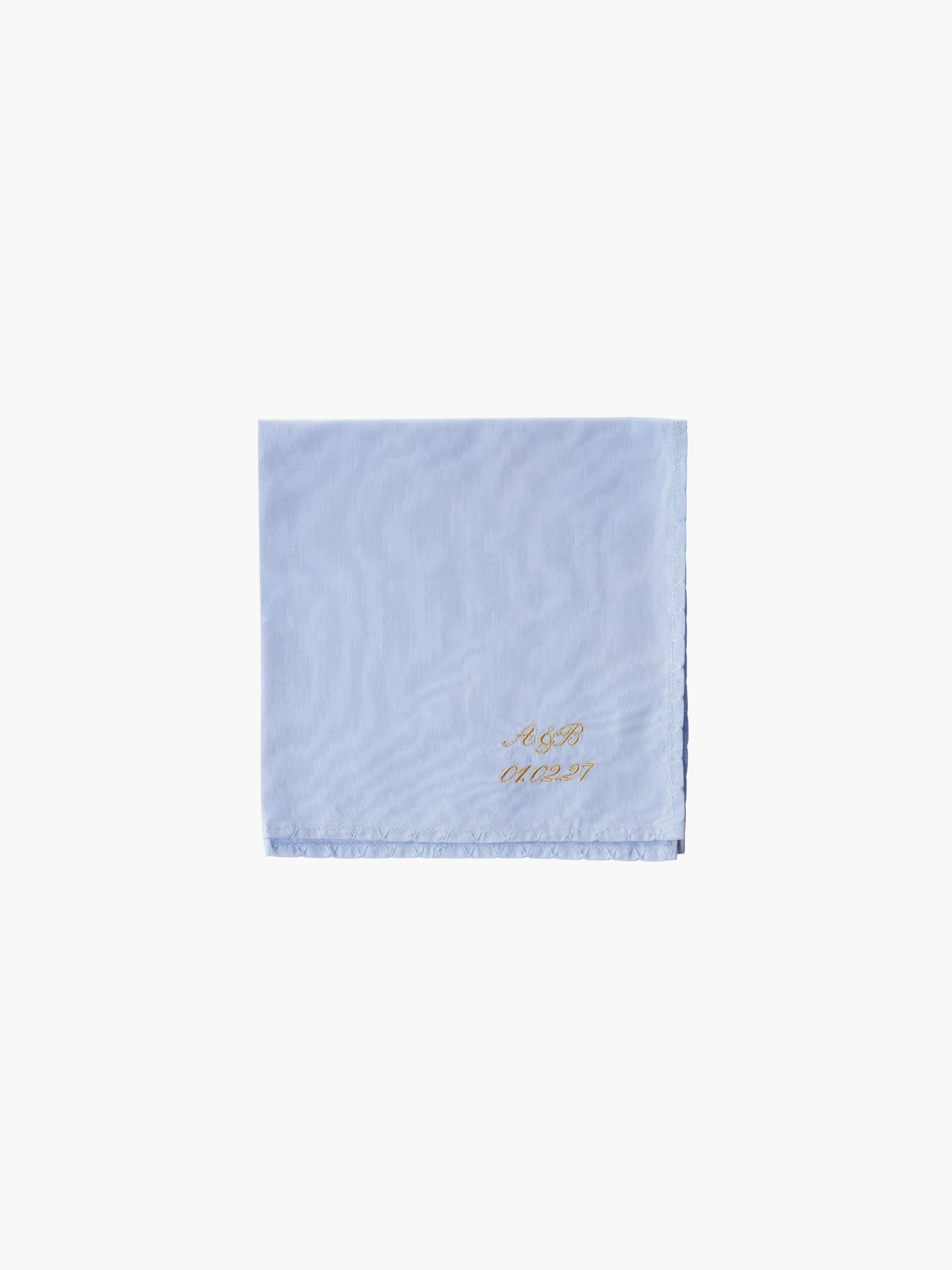 A blue cotton embroidered square handkerchief, embroidered with initials and the date in gold. 