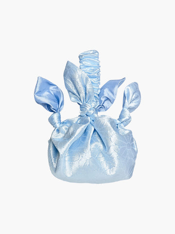 blue floral satin knotted handbag on a white background