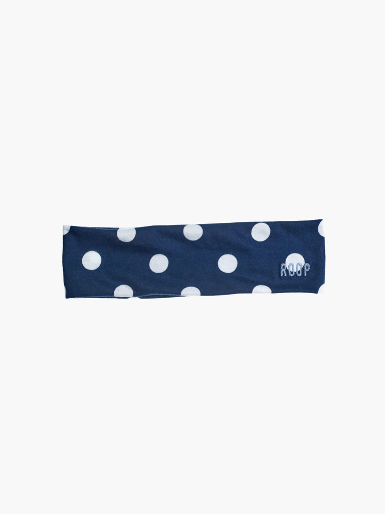 Navy blue stretch headband with white polka dots and 'ROOP' branding on a white background