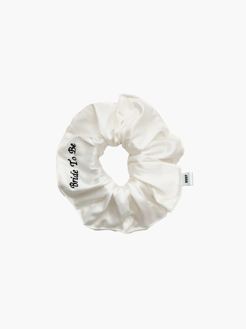 Ivory bamboo silk satin scrunchie with 'Bride To Be' embroidered in black on a white background.