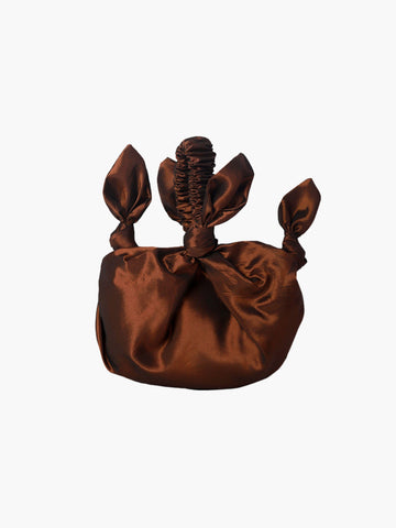 bronze knotted taffeta handbag on a white background