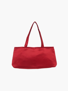 A sleek burgundy handbag with a minimalist design, featuring a rectangular shape and two thin straps. The tone is elegant and versatile against a plain white background.