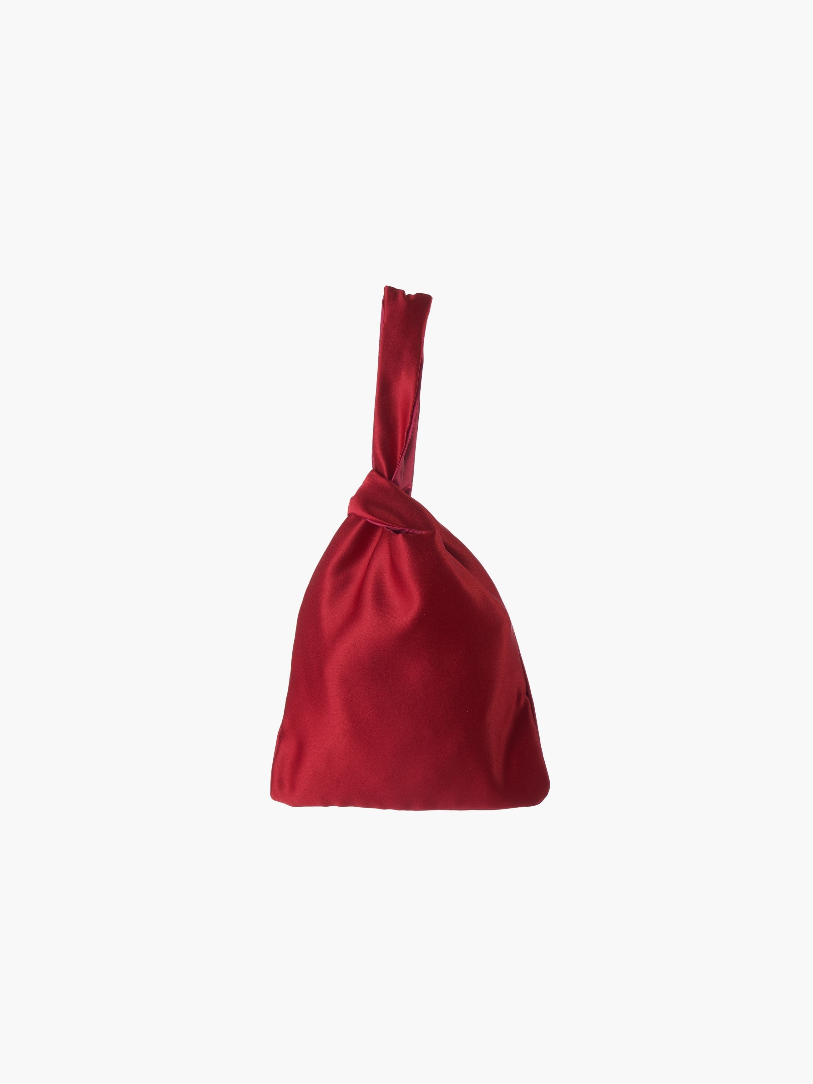 Burgundy satin knot bag against a plain white background. The elegant bag has a twisted handle and sleek, glossy fabric, exuding a chic, minimalist style.