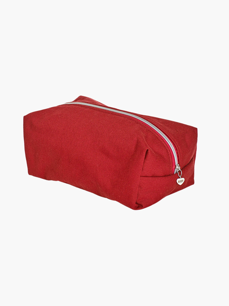 burgundy padded makeup and toiletry bag with a silver zip with a heart logo zip pull on a white background