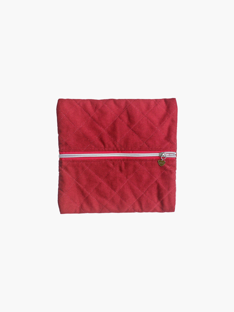 A quilted burgundy cotton zipper pouch, the zip has a heart charm on it. Set on a white background.