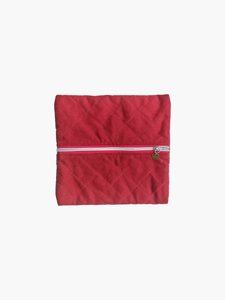 A quilted burgundy cotton zipper pouch, the zip has a heart charm on it. Set on a white background.