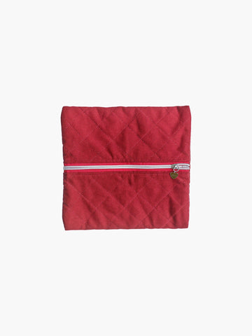 A quilted burgundy cotton zipper pouch, the zip has a heart charm on it. Set on a white background.