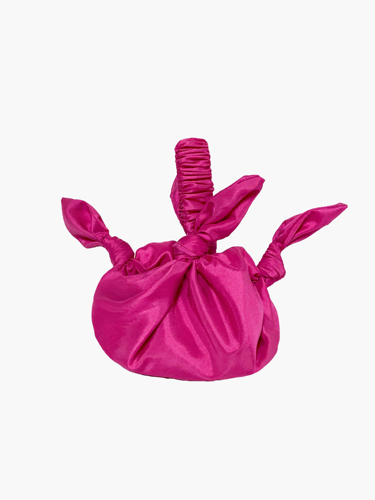 Pink knotted headband on a white background