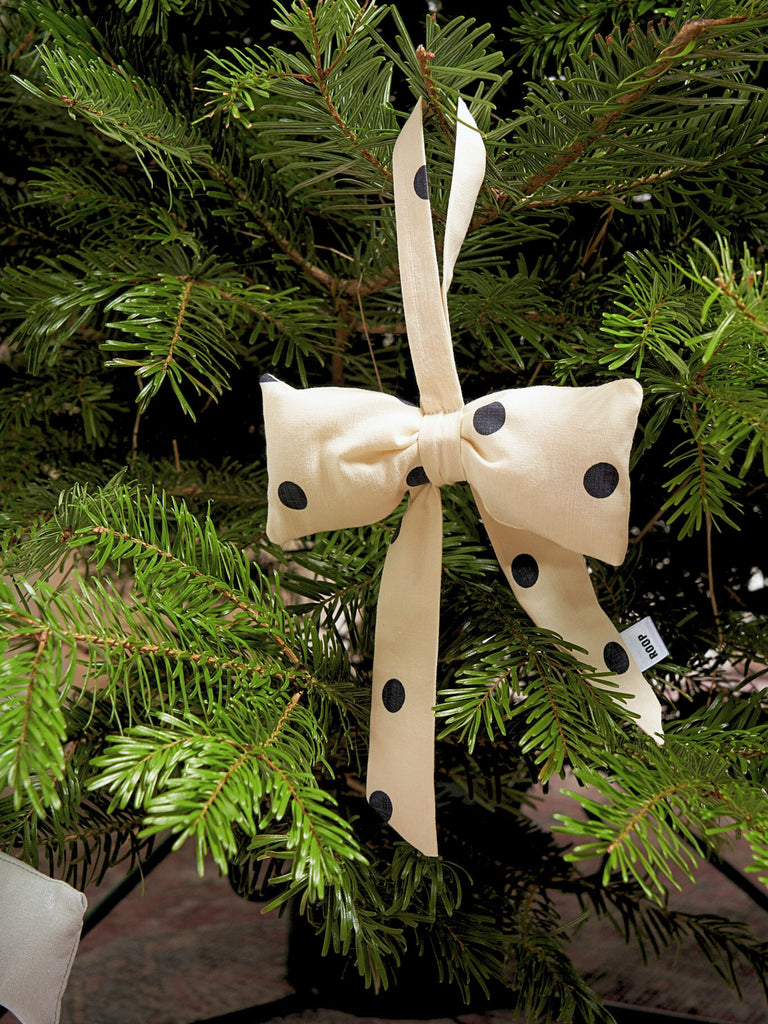 Cream bow with black dots hanging on a Christmas tree