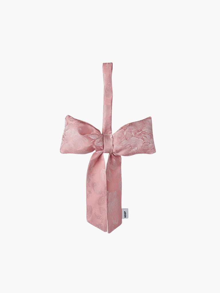 Pink floral satin bow-shaped decorative item on a white background