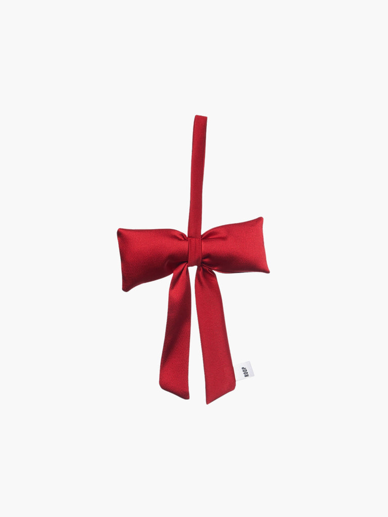 A red satin padded fabric bow featuring a loop for hanging. The bow exudes a playful and decorative feel.