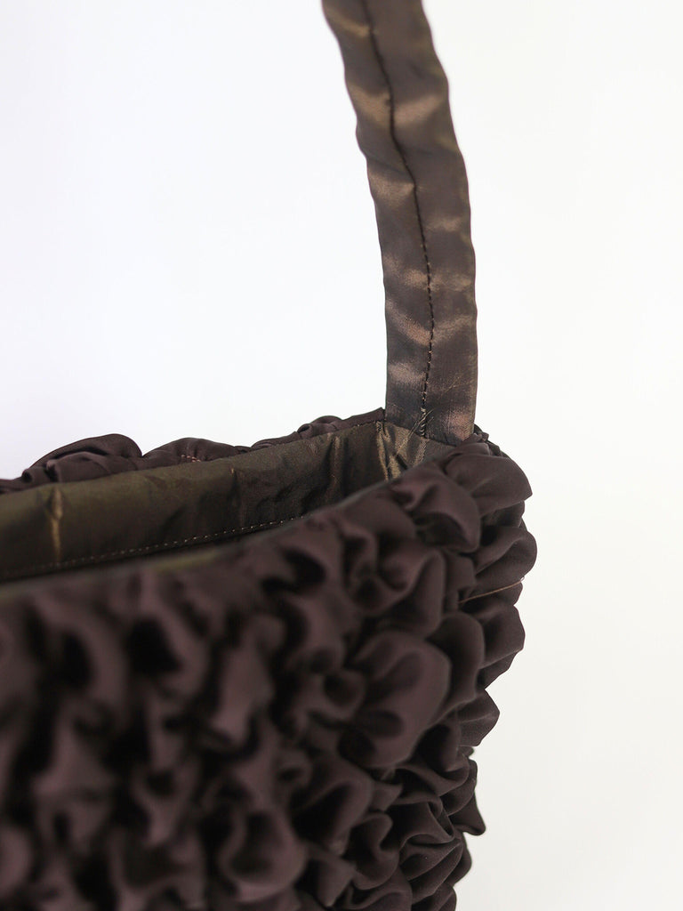Close-up of a brown textured satin bag with a white background
