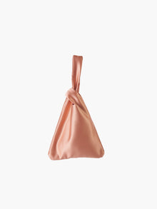 Rose gold satin knot bag against a plain white background. The elegant bag has a twisted handle and sleek, glossy fabric, exuding a chic, minimalist style.