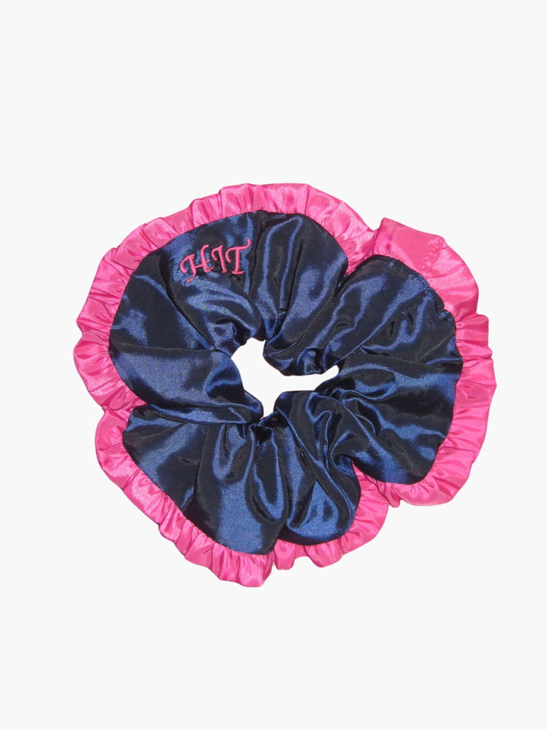 Navy blue scrunchie with pink ruffled trim and pink embroidered initials on a white background