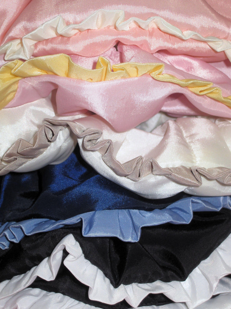 Stack of colourful taffeta ruffle edge scrunchies in various colours.