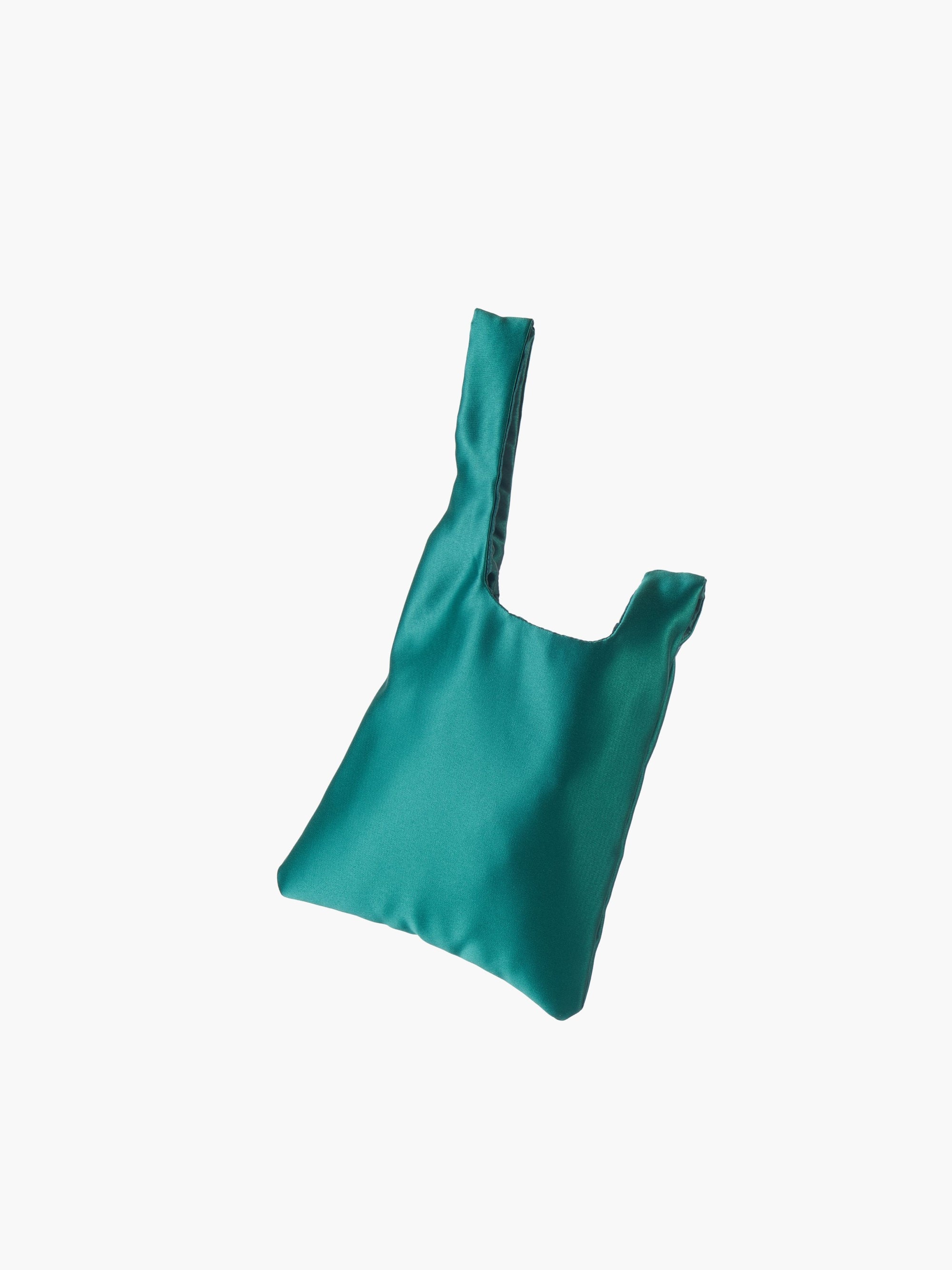 Emerald satin knot bag against a plain white background. The elegant bag has a twisted handle and sleek, glossy fabric, exuding a chic, minimalist style.