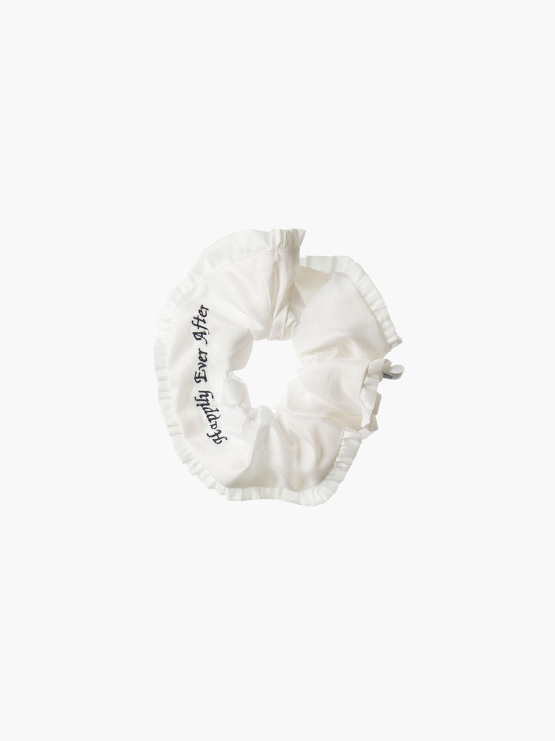 Ivory ruffled scrunchie with black embroidery that reads 'happily ever after' on a white background