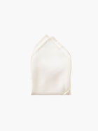 An ivory folded pocket square made from silk, set against a white background.