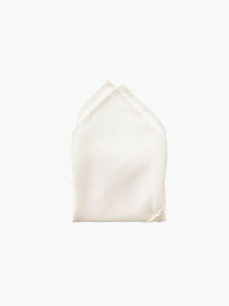 An ivory folded pocket square made from silk, set against a white background.