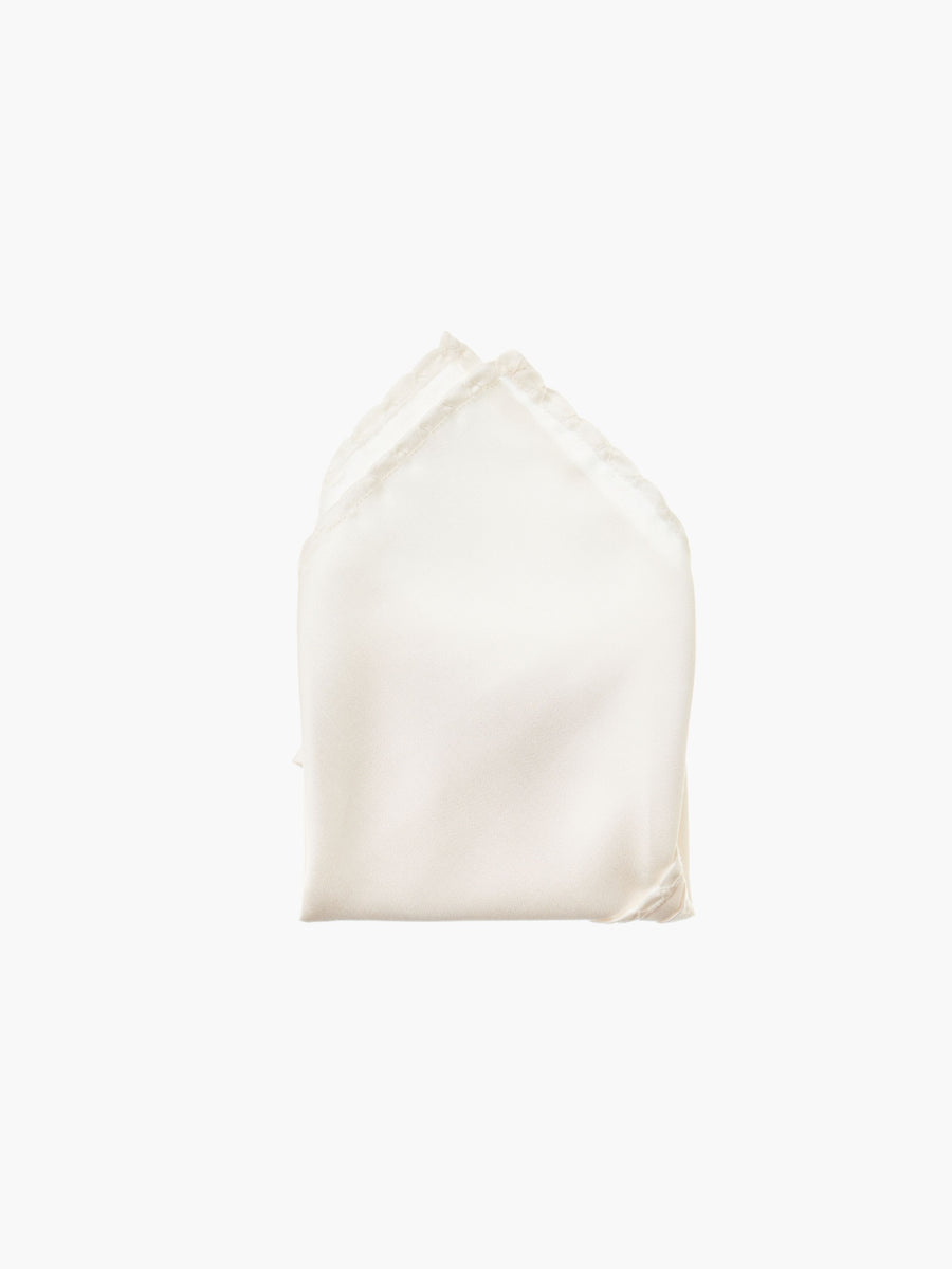 An ivory folded pocket square made from silk, set against a white background.
