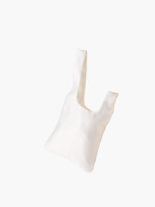 Ivory satin knot bag against a plain white background. The elegant bag has a twisted handle and sleek, glossy fabric, exuding a chic, minimalist style.