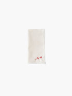 A folded cream-colored cloth napkin with a red embroidered rose design in the corner, set against a plain white background. Simple and elegant.