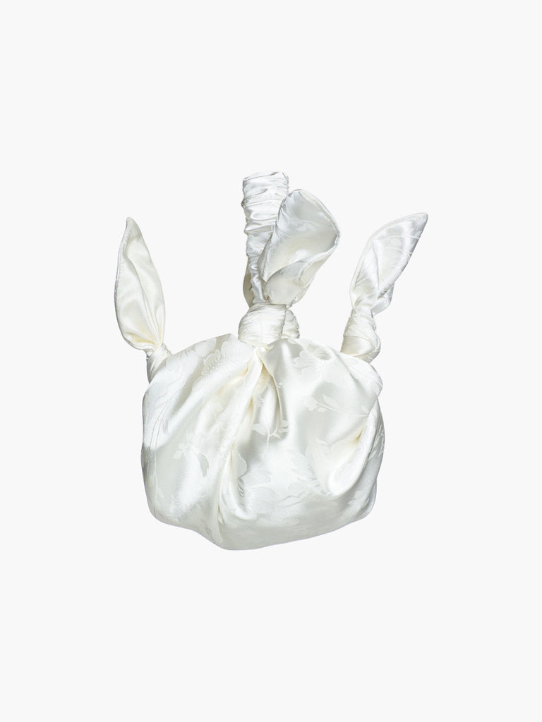 Ivory satin knotted handbag with a subtle floral pattern