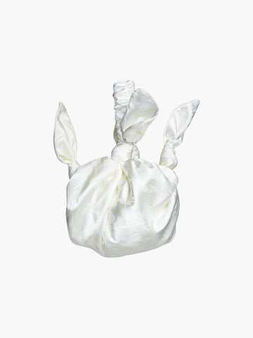 Ivory satin knotted handbag with a subtle floral pattern