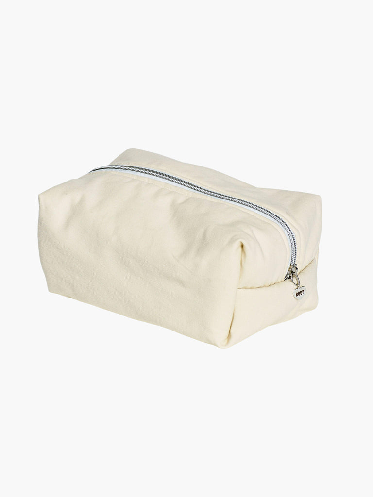 ivory padded makeup and toiletry bag with a silver zip with a heart logo zip pull on a white background