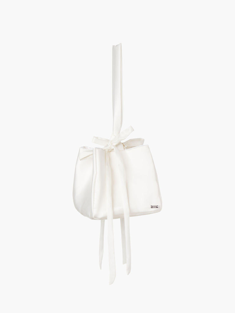 Ivory satin box handbag with a long handle and bow details, set on a white background