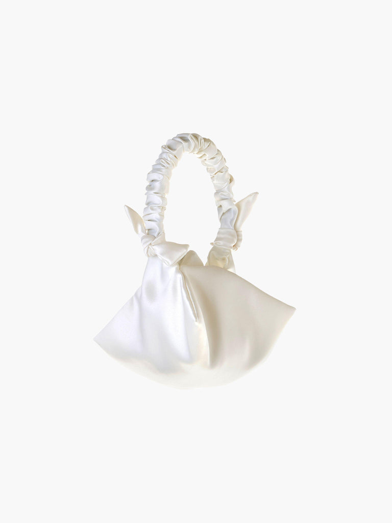Ivory satin ruched handle handbag with decorative bows, set on a white background