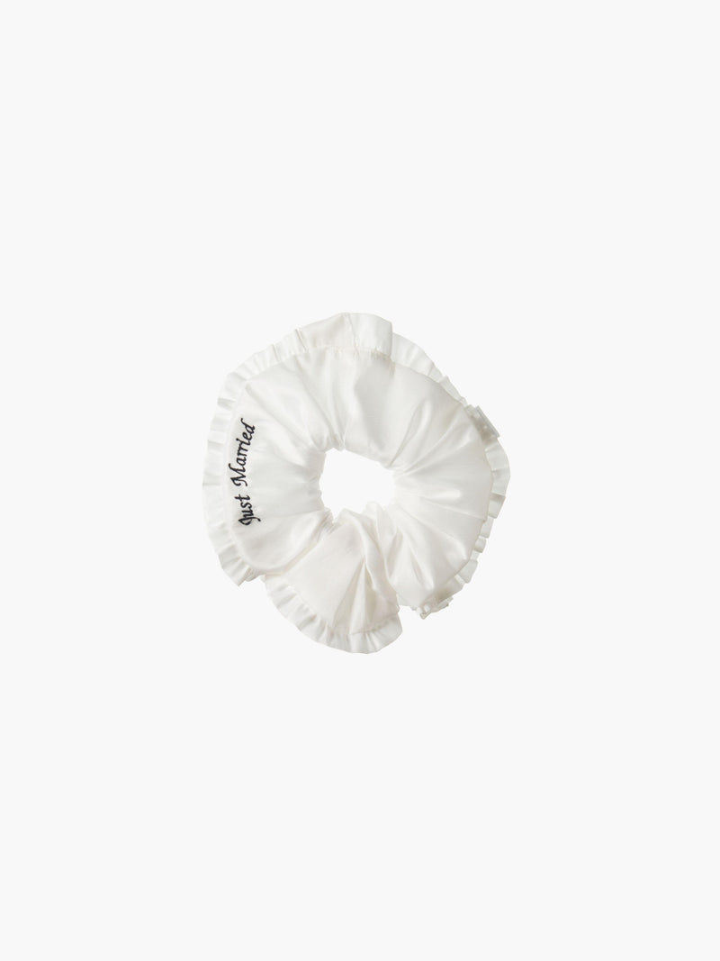 Ivory ruffled scrunchie with black embroidery that reads 'just married' on a white background