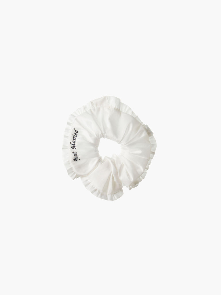 Ivory ruffled scrunchie with black embroidery that reads 'just married' on a white background