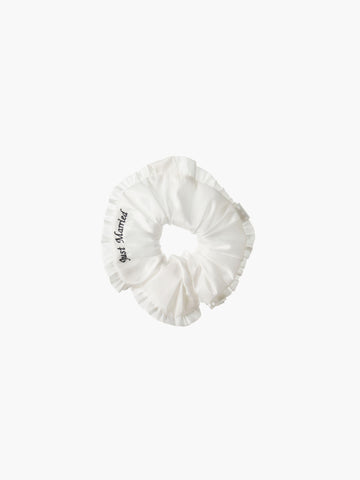 Ivory ruffled scrunchie with black embroidery that reads 'just married' on a white background