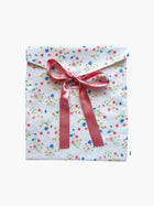 Floral-patterned gift bag with a pink ribbon on a white background