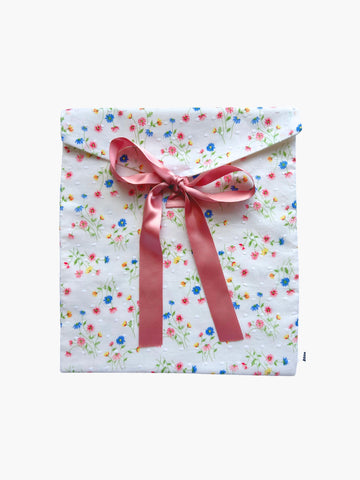Floral-patterned gift bag with a pink ribbon on a white background